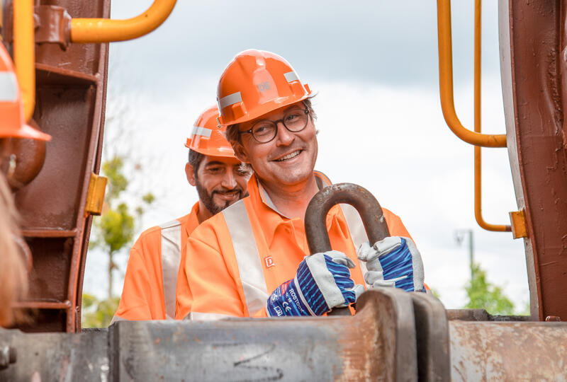 Andreas Scheuer verbindet / trennt zwei Wagons. Der Bundesverkehrsminister Andreas Scheuer und die Vorständin der DB und Vorstandsvorsitzende der DB Cargo Sigrid Nikutta präsentierten am 7. Juni 2021 in München die Digitalisierung und Neuerung im Rangierbahnhof vor.   *   Andreas Scheuer works on a coupling of two freight cars. The German minister of transport Andreas Scheuer ( CSU ) and the board member of the Deutsche Bahn and CEO of the DB Cargo Sigrid Nikutta on June 7 2021 presented the digitalisation of the marshalling yard in Munich, Germany.