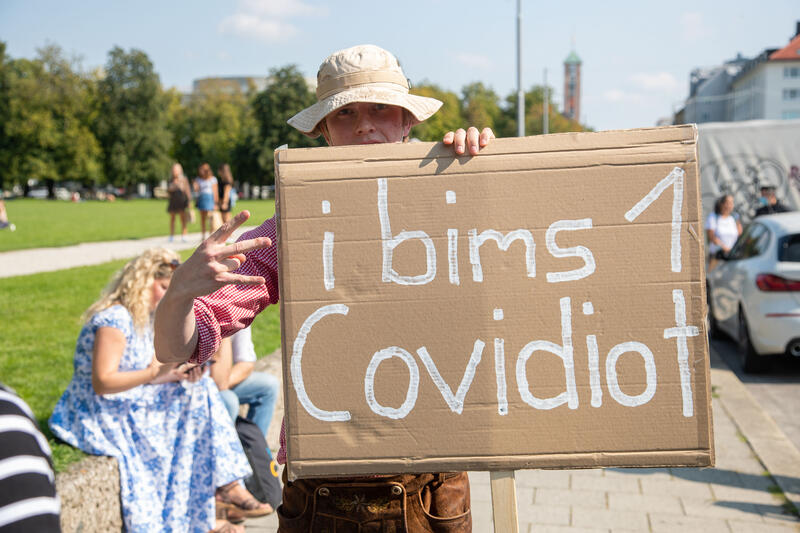 Aktivist in Lederhosn und Schild: " i bims 1 Covidiot ". Am 12. September 2020 haben sich zuerst 500 Menschen in München auf einer Demo zur Theresienwiese versammelt. Diese Demo wurde von der Polizei wegen der nicht eingehaltetenen Maskenpflicht von der Polizei gestoppt und anschließend vom Veranstalter aufgelöst. Auf der Theresienwiese versammelten sich Tausende Menschen, die nur in den seltensten Fällen eine Maske trugen. Auch Mindestabstände wurden nicht immer eingehalten. Die Polizei stoppte die Versammlung mehrmals.  --  Thousands protested on September 12th 2020 in Munich against the measures against covid-19 and the request of wearing a mask.