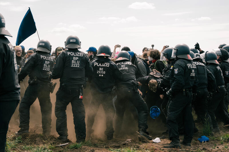 Am 10.05.2024 versuchten ca. 800 Aktivist*innen auf das Gelände der Gigafactory von Tesla zu gelangen. Auf ihrer Website schreiben sie hierzu: " Hier [Grünheide] markieren Aktivist*innen den Tesla Konzern als Verantwortlichen für Grundwasserverseuchung, Ressourcenraub und die Gefährdung von Menschen ".

On May 10, 2024, around 800 activists tried to enter the Tesla Gigafactory site. On their website they write: " Here [Gruenheide] activists mark the Tesla company as responsible for groundwater contamination, resource theft and the endangerment of people ".