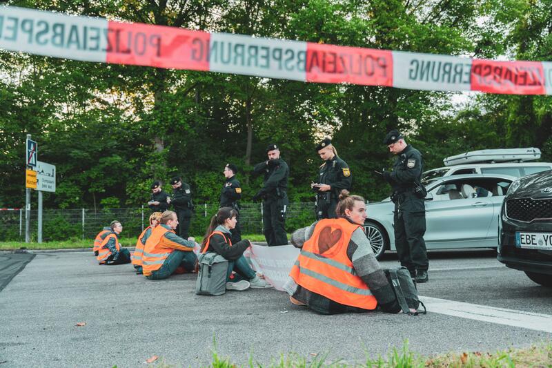 Am 4.9.2023 blockierten Aktivist*innen der Letzten Generation in München zahlreiche Straßen. Journalist*innen wurden von der Polizei rechtswidrig erkennungsdienstlich behandelt.Zuvor gab es durch einen Autofahrer einen körperlichen Übergriff auf einen Journalisten. Die LG veranstaltet die Protestphase in Bayern, weil sie hier die größten Blockierer von Klimapolitik sehen. Außerdem fordert ein Tempolimit von 100 km/h auf Autobahnen, die Einführung eines Neun-Euro-Tickets und einen Gesellschaftsrat Klima. -- On September 4, 2023 activists of the Last Generation blocked several roads in Munich, Germany. Journalists were unlawfully identified by the police. Prior a journalist was physically attacked by a car driver. The LastGen sees the Bavarian policy makers as worst climate policy blockers. Further the Last Generation demands a speed limit of 100 km/h on highways, the introduction of a nine-euro ticket and a Climate Society Council.