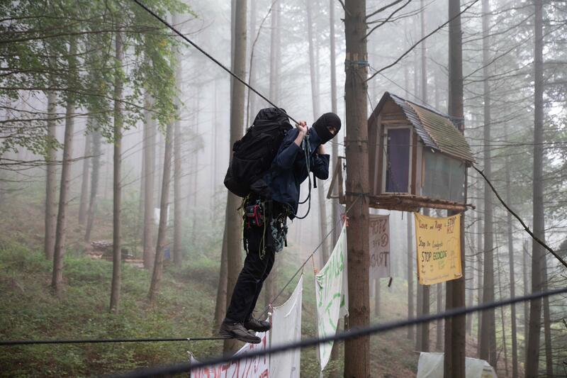 8. Oktober 2022: Ein Aktivist klettert über eine Seilbrücke von einem Baumhaus in die gemeinschaftliche Küche der Besetzung. - October 8, 2022: An activist climbs over a rope bridge from a tree house into the communal kitchen of the occupation.