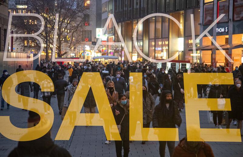 Mehrfachbelichtung von einem Plakat zum Black Friday und Menschen, die am 27. November 2020 in der Münchner Fußgängerzone  zum Black Friday shoppen. Mit der Black Week bzw. dem Black Friday beginnt traditionell das Weihnachtsgeschäft. Heuer mit Maskenpflicht und Abstandsgebot.   --   Multiple exposure of a sign on the black friday and people shopping on November 27th in the Munich pedestrian zone. With the Black Week or Black Friday the christmas season traditionally begins. This year with compulsory masks and physical distancing.