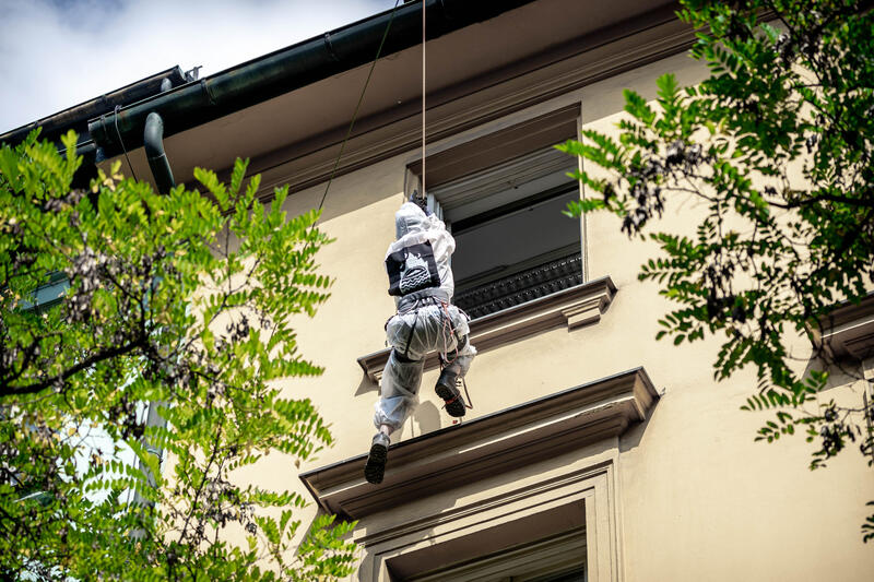 Aktivist*in klettert vom Dach. Am 10.09.2021 fand anlässlich der Austragung der IAA in München ein Aktionstag statt, bei welchem mehrere Aktionen und Blockaden gegen die IAA in verschiedenen Fingern stattfinden, wie hier der NoFuture-Finger bei welchen es zu einer Auseinandersetzung zwischen Aktivist*innen und Polizist*innen gekommen ist sowie zu einer Hausbesetzung in der Karlstraße 20.   *   Activist climbing from the roof. On September 10, 2021 there was a day of action against the IAA Mobilty in Munich, Germany. Activists made demonstrations and blockades in different fingers. The No Future for IAA finger here was stopped by police and there was in parts police brutality against a few activists. The Karlstraße 20 and 22 were squatted.