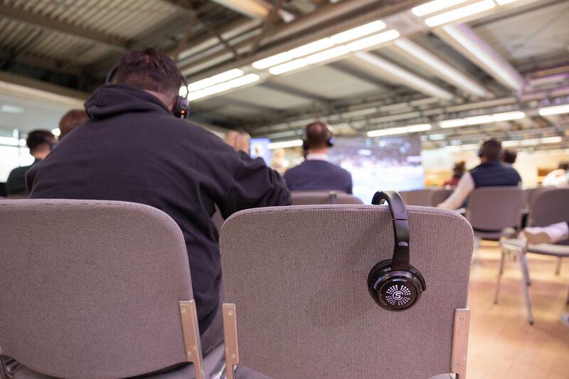 Zuschauer hören mit Kopfhörern dem Referenten zu beim Sport Marke Medien am Media Day der ISPO 2024, einer Fachmesse und Business-Festival für die Sport-, Lifestyle-, Health- und Techindustrie am 02.12.2024 in München.   --   People listen to the speakers with headphones at the Sport Marke Medien at the Media Day of the ISPO 2024, a trade fair and business festival fot the sports, lifestyle and tech industry on December 2nd, 2024 in Munich, Germany.
