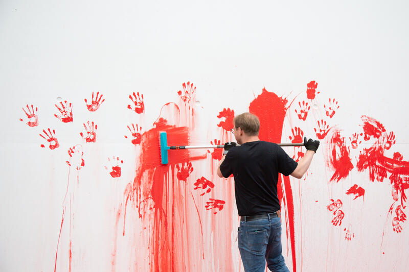 Reinigungsteam säubern die Stelle. Am 07.07.2025 um 12 Uhr beschmierten Aktivist*innen von Palestine Rising die rechte Seite der Fassade des Bundeskanzleramtes in Berlin, Deutschland. Sie hinterließen rote Handabdrücke an der Wand. Sie demonstrieren damit gegen die deutsche Unterstützung von Kriegsverbrechen in Gaza.   --    Cleaning team cleans the wall after the action. On July 7, 2025 activists from Palestine Rising, a group of the New Generation, smeared the facade of the federal chancellery in Berlin, Germany with red paint. They left red hand prints at the wall. With their action the activists protest against German support for the Israeli war crimes in Gaza.