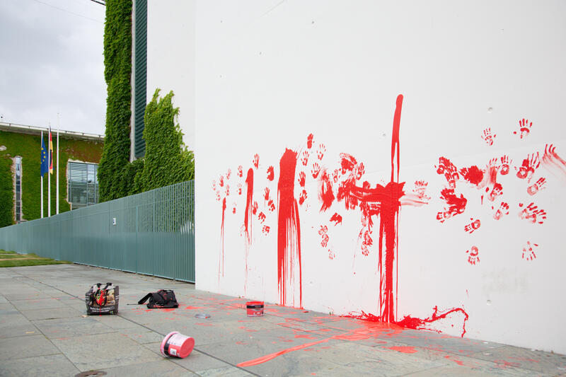 Am 07.07.2025 um 12 Uhr beschmierten Aktivist*innen von Palestine Rising die rechte Seite der Fassade des Bundeskanzleramtes in Berlin, Deutschland. Sie hinterließen rote Handabdrücke an der Wand. Sie demonstrieren damit gegen die deutsche Unterstützung von Kriegsverbrechen in Gaza.   --    On July 7, 2025 activists from Palestine Rising, a group of the New Generation, smeared the facade of the federal chancellery in Berlin, Germany with red paint. They left red hand prints at the wall. With their action the activists protest against German support for the Israeli war crimes in Gaza.