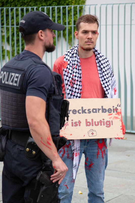 Am 07.07.2025 um 12 Uhr beschmierten Aktivist*innen von Palestine Rising die rechte Seite der Fassade des Bundeskanzleramtes in Berlin, Deutschland. Sie hinterließen rote Handabdrücke an der Wand. Sie demonstrieren damit gegen die deutsche Unterstützung von Kriegsverbrechen in Gaza.   --    On July 7, 2025 activists from Palestine Rising, a group of the New Generation, smeared the facade of the federal chancellery in Berlin, Germany with red paint. They left red hand prints at the wall. With their action the activists protest against German support for the Israeli war crimes in Gaza.