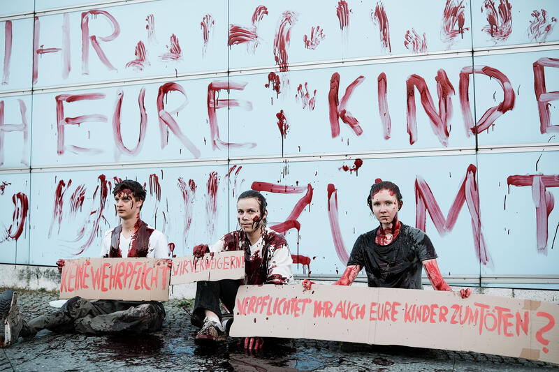 Am 02.09.2025 gegen 19 Uhr bemalten drei junge Aktivist*innen die Wand vom Kindergarten des Bundestags mit den Worten " Verpflichtet ihr auch eure Kinder zum Töten? " mit Kunstblut, um gegen eine mögliche Wehrpflicht zu demonstrieren. Auf Schildern stand zusätzlich " Wir verweigern ".   --   On September 2, 2025 three young activists wrote " Do you also draft your children to kill? " on the wall of the kindergarden of the Bundestag with artificial blood to protest against the planned reintroduction of the conscription. On signs there was written " We object ".