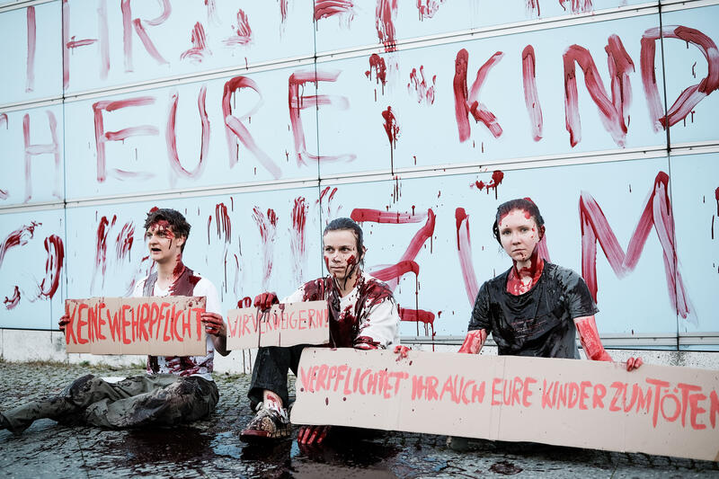 Am 02.09.2025 gegen 19 Uhr bemalten drei junge Aktivist*innen die Wand vom Kindergarten des Bundestags mit den Worten " Verpflichtet ihr auch eure Kinder zum Töten? " mit Kunstblut, um gegen eine mögliche Wehrpflicht zu demonstrieren. Auf Schildern stand zusätzlich " Wir verweigern ".   --   On September 2, 2025 three young activists wrote " Do you also draft your children to kill? " on the wall of the kindergarden of the Bundestag with artificial blood to protest against the planned reintroduction of the conscription. On signs there was written " We object ".