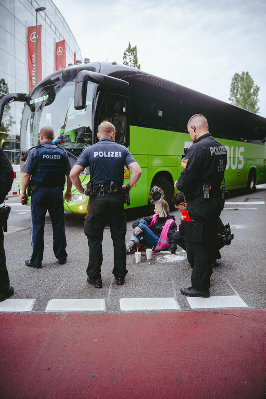 Am Morgen des 9. September 2025 blockierten Aktivist*innen des Widerstandskollektivs die Landshuter Allee in München, Deutschland, vor dem Mercedes Showroom, um gegen die IAA (Internationale Automobil-Ausstellung) zu protestieren.
Einige saßen dabei nur auf der Straße, andere klebten oder betonierten sich fest. Die festbetonierte Aktivist*in musste mit Hilfe einer Flex gelöst werden. --   On the morning of September 9, 2025, activists from the Resistance Collective blocked Landshuter Allee in Munich, Germany, in front of the Mercedes showroom to protest against the IAA (International Motor Show).
Some just sat on the street, others stuck or concreted themselves down.
The concreted activist had to be loosened with the help of an angle grinder.