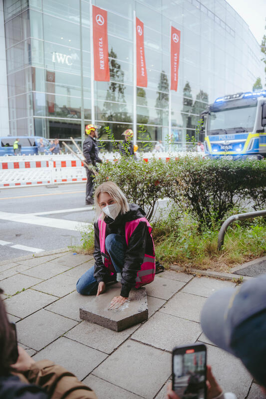 Am Morgen des 9. September 2025 blockierten Aktivist*innen des Widerstandskollektivs die Landshuter Allee in München, Deutschland, vor dem Mercedes Showroom, um gegen die IAA (Internationale Automobil-Ausstellung) zu protestieren.
Einige saßen dabei nur auf der Straße, andere klebten oder betonierten sich fest. Die festbetonierte Aktivist*in musste mit Hilfe einer Flex gelöst werden. --   On the morning of September 9, 2025, activists from the Resistance Collective blocked Landshuter Allee in Munich, Germany, in front of the Mercedes showroom to protest against the IAA (International Motor Show).
Some just sat on the street, others stuck or concreted themselves down.
The concreted activist had to be loosened with the help of an angle grinder.