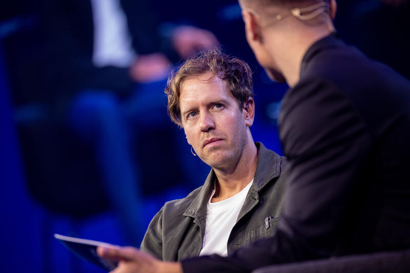 Sebastian Vettel, Simon Schütz, VDA Head of Communications,  bei der IAA Conference auf der IAA Mobility am 09.09.2025 in München.   --   Sebastian Vettel, Simon Schuetz, VDA Head of Communications, at the IAA Conference at the IAA Mobility on September 9, 2025 in Munich, Germany.