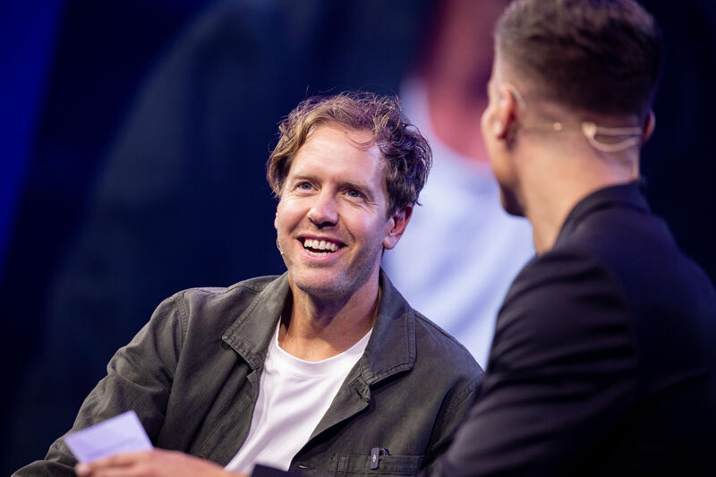 Sebastian Vettel, Simon Schütz, VDA Head of Communications,  bei der IAA Conference auf der IAA Mobility am 09.09.2025 in München.   --   Sebastian Vettel, Simon Schuetz, VDA Head of Communications, at the IAA Conference at the IAA Mobility on September 9, 2025 in Munich, Germany.