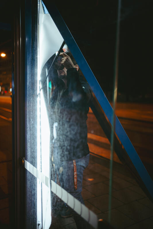 In der Nacht auf den 10.09.2025 versuchten zwei Aktivist:innen von Attac eine Adbusting-Aktion. Sie entfernten einige Werbeplakate und wollten sie durch Plakate gegen die IAA ersetzen. Da sie unvorbereitet waren, konnten sie einige Werbekästen nicht öffnen, einige konnten sie hingegen öffnen, aber ihre Plakate nicht aufhängen. Der Protest von Attac gegen die IAA begleiten sie mit der Froderung, nach einer sozial-ökologischen Wende in der Automobilindustrie und im gesamten Wirtschaftssystem. Sie fordern: Weniger Autos, und stattdessen mehr Platz für Fahrräder und Fußwege. -- On the night of September 10, 2025, two Attac activists attempted an adbusting campaign. They removed several advertising posters and wanted to replace them with posters against the IAA. Since they were unprepared, they were unable to open some of the advertising boxes, while others they were able to open but could not hang their posters. Attac's protest against the IAA is accompanied by demands for a socio-ecological transformation of the automotive industry and the entire economic system. They are calling for fewer cars and more space for bicycles and footpaths instead.