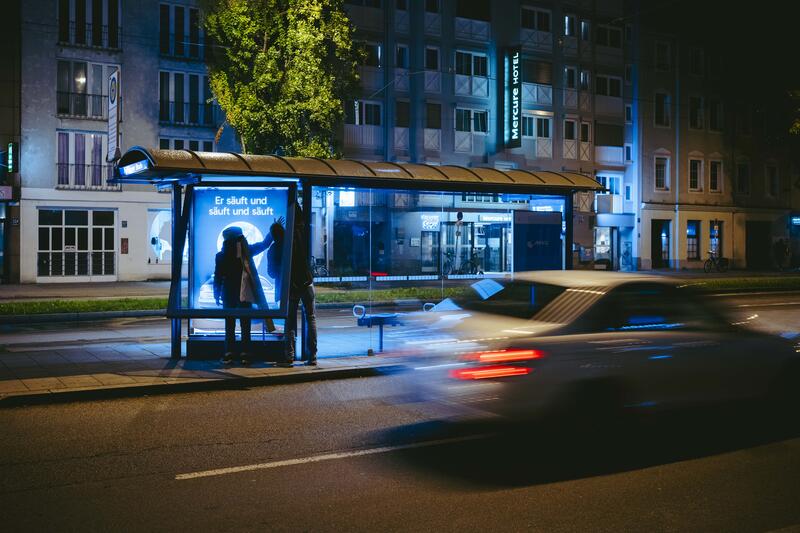 In der Nacht auf den 10.09.2025 versuchten zwei Aktivist:innen von Attac eine Adbusting-Aktion. Sie entfernten einige Werbeplakate und wollten sie durch Plakate gegen die IAA ersetzen. Da sie unvorbereitet waren, konnten sie einige Werbekästen nicht öffnen, einige konnten sie hingegen öffnen, aber ihre Plakate nicht aufhängen. Der Protest von Attac gegen die IAA begleiten sie mit der Froderung, nach einer sozial-ökologischen Wende in der Automobilindustrie und im gesamten Wirtschaftssystem. Sie fordern: Weniger Autos, und stattdessen mehr Platz für Fahrräder und Fußwege. -- On the night of September 10, 2025, two Attac activists attempted an adbusting campaign. They removed several advertising posters and wanted to replace them with posters against the IAA. Since they were unprepared, they were unable to open some of the advertising boxes, while others they were able to open but could not hang their posters. Attac's protest against the IAA is accompanied by demands for a socio-ecological transformation of the automotive industry and the entire economic system. They are calling for fewer cars and more space for bicycles and footpaths instead.