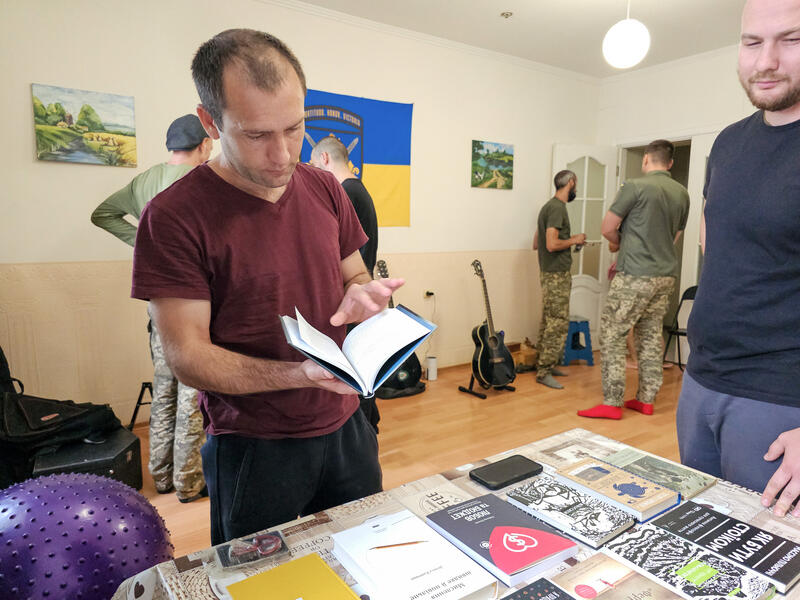Einer der beiden Soldaten der sich dort im Rehabilitationszentrum in Behandlung befindet schaut sich die Buchauswahl an. Fotografiert am 9. September 2025.   One of the two soldiers undergoing treatment at the rehabilitation centre looks at the selection of books. Photographed on 9 September 2025.