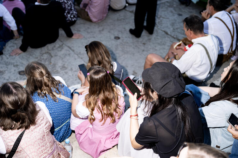 Besucherinnen am Handy. Impressionen vom Oktoberfest am ersten Wiesnsonntag am 21.09.2025 in München.   --   Visitors looking on the phone. Impression from the Oktoberfest on the first sunday on September 21, 2025 in Munich, Germany.