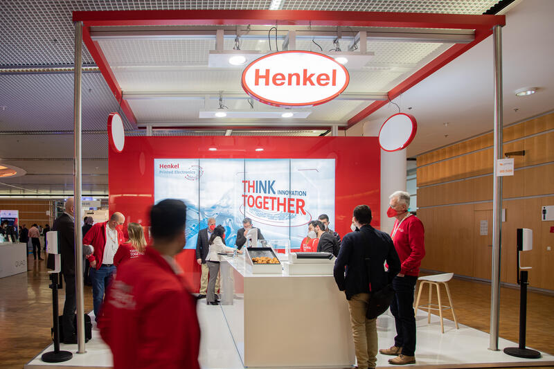 Stand von Henkel bei der Lopec Messe am 24.3.2022 in München. Die LOPEC ist eine jährliche Fachmesse für gedruckte und organische Elektrinik.   -   Stand of Henkel at the Lopec trade fair on March 24, 2022 in Munich, Germany. The LOPEC is a yearly hold trade fair for organic and printed electrinics.
