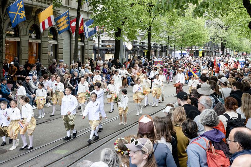 Kinder der thailändischen Delegation im Vordergrund , dahinter die tibetische Delegation auf der Bahnhofstrasse. Fotografiert am 19. April 2026.   Children from the Thai delegation in the foreground, with the Tibetan delegation behind them on Bahnhofstrasse. Photographed on 19 April 2026.