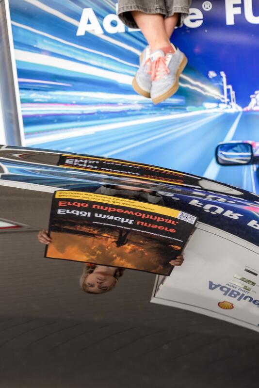 Aktion der Gruppierung "act now!" an der Tankstelle der Raststätte Würenlos, Schweiz am 10.05.2026. Act now! Aktivist:innen stellten sich mit Plakaten als Warnhinweise wie bei Zigaretten an die Shell Tankstelle. Sie fordern in der aktuellen Kampagne sie solche Warnhinweise bei Tankstellen.   --    Action by the "act now!" group at the petrol station at the Wuerenlos, Switzerland motorway service station on May 10, 2026. Activists stood along a Shell gas station holding signs featuring warnings similar to those on cigarette packages. In their current campaign, they are calling for such warnings to be displayed at gas stations.