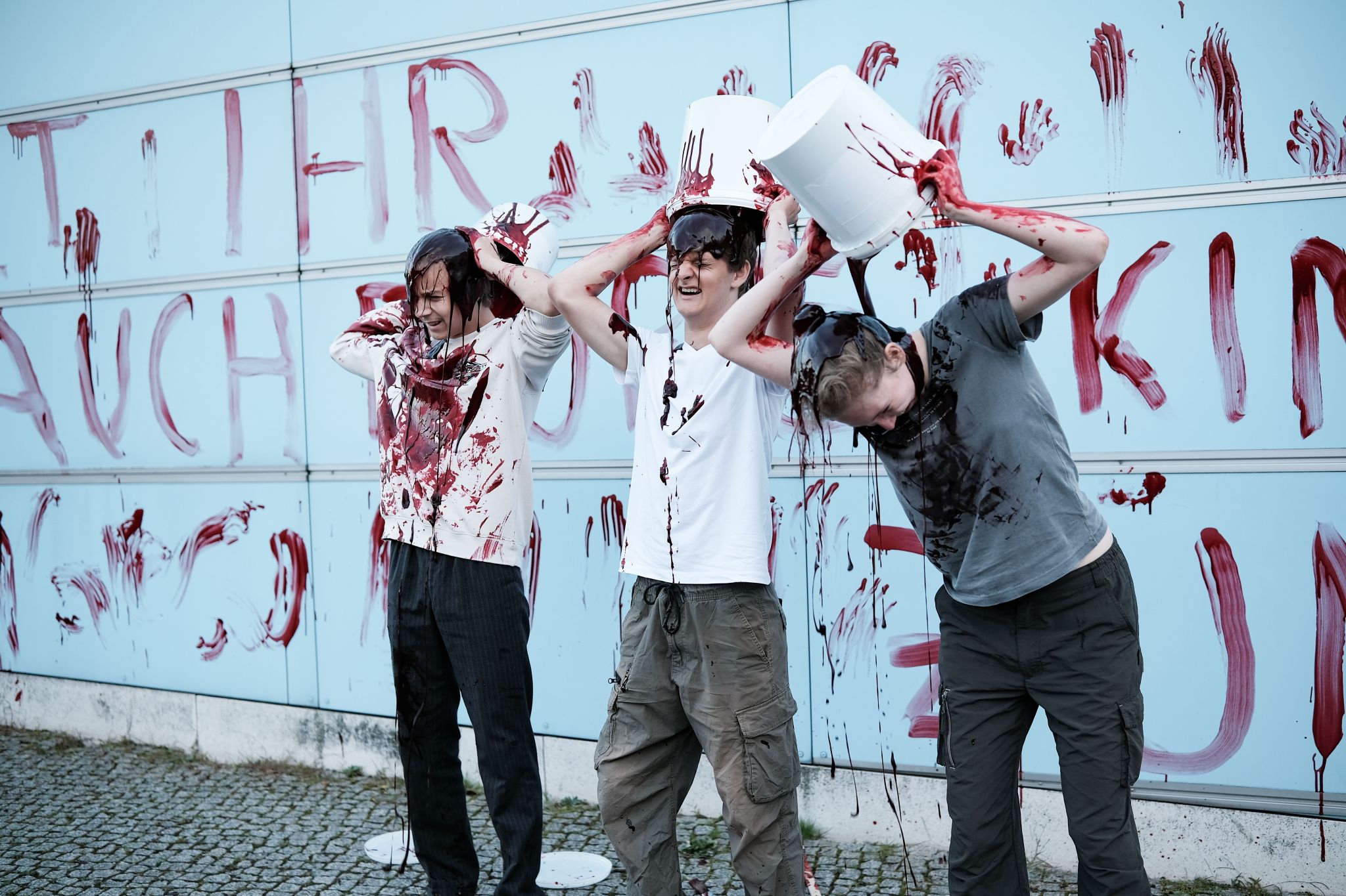 Am 02.09.2025 gegen 19 Uhr bemalten drei junge Aktivist*innen die Wand vom Kindergarten des Bundestags mit den Worten &quot; Verpflichtet ihr auch eure Kinder zum Töten? &quot; mit Kunstblut, um gegen eine mögliche Wehrpflicht zu demonstrieren. Auf Schildern stand zusätzlich &quot; Wir verweigern &quot;.   --   On September 2, 2025 three young activists wrote &quot; Do you also draft your children to kill? &quot; on the wall of the kindergarden of the Bundestag with artificial blood to protest against the planned reintroduction of the c